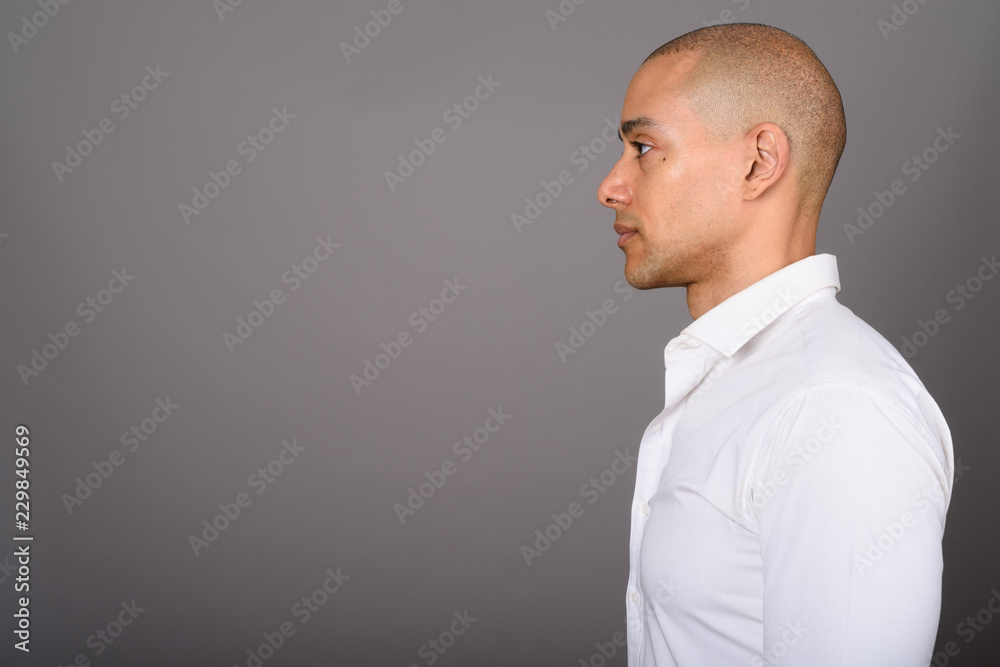 Wall mural profile view of handsome bald businessman against gray background