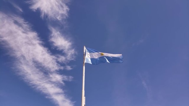 Argentine flag slowly waving in a blue sky. Slow motion.
Bandera Argentina, flameando suavemente con el viento en un cielo celeste.