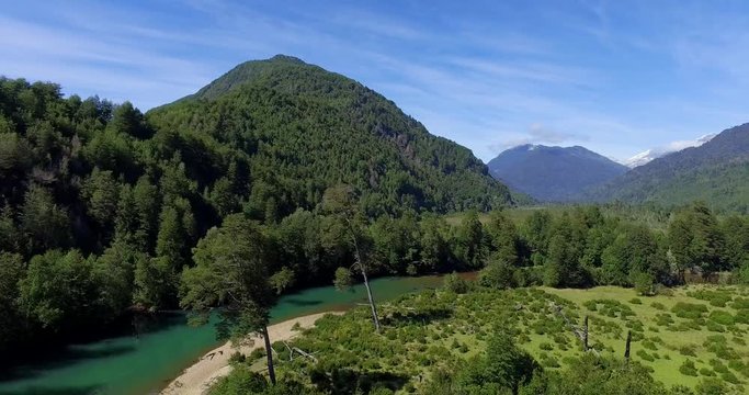 Aerial view at low altitude of the Traidor River surrounded by native and pristine forest, Chilean Patagonia