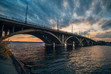 Fototapeta na wymiar Vogres bridge over Voronezh river on sunset and dramatic sky background