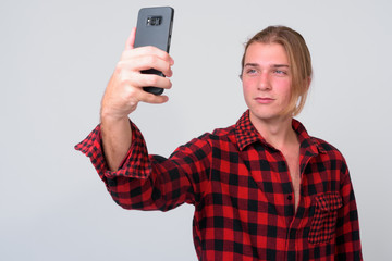Young handsome hipster man with long blond hair