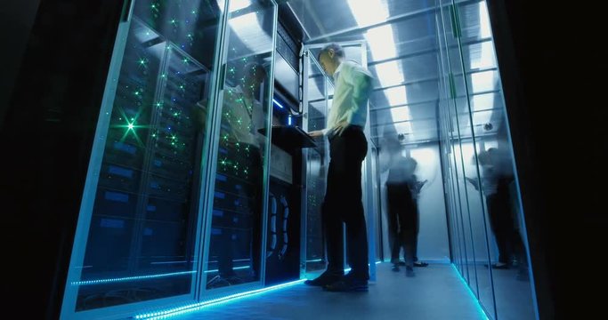 From below view in time lapse of diverse engineers working in data center and leaving room with light going out