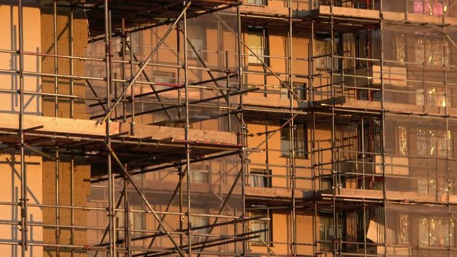 Kennedy Gardens apartments in Billingham, Teesside surrounded by scaffolding and having combustible cladding removed. Close up shot of a corner of scaffolding in the early evening golden sunlight.