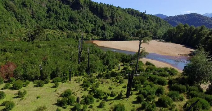 Aerial view at low altitude of the Traidor River surrounded by native and pristine forest, Chilean Patagonia