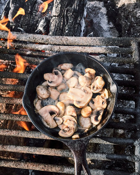 Cooking mushrooms in a fire pit while camping