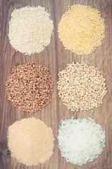 Vintage photo, Gluten free white rice and groats on rustic board, healthy food concept