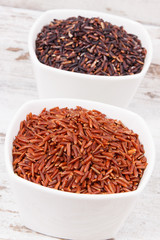 Fototapeta na wymiar Black and red rice in glass bowls, healthy, gluten free nutrition concept
