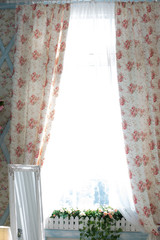 the window in the kitchen. curtains with flowers. white flower curtains. window