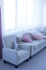 sofa with pillows. couch and chair. pink pillows. sofa by the window. interior of the room