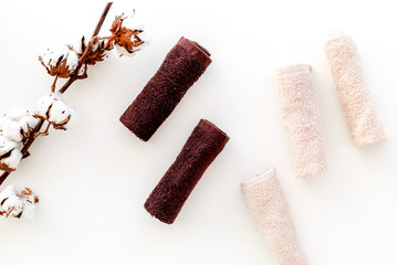 Cotton towels high quality. Set of towels twisted coil near dry cotton flowers on white background top view