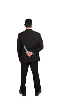 portrait businessman hold knife on the back isolated on white background (comparing betrayal concept)