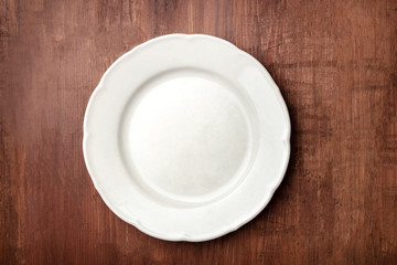 White plate, shot from above on a dark rustic wooden background with a place for text