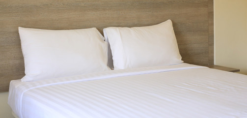 Close-up white pillows on bed in hotel.