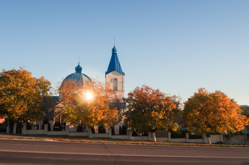 Fototapeta na wymiar Christian Church on the road in autumn at sunset.