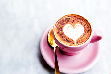 Cappuccino cup with heart latte art on marble table background