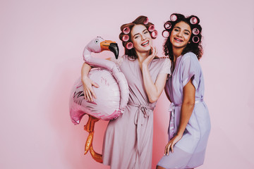 Two Happy Women in Bathrobes on Pink Background.