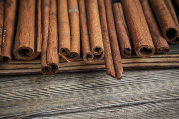 Cinnamon sticks on wooden background.