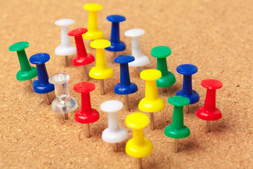 Group of thumbtacks pinned on corkboard close up. School or business concept
