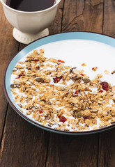 Granola, oatmeal with milk, honey and fruit on wooden table.

