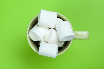 sweet marshmallow, candy on green background, top view