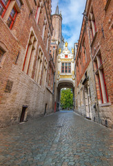 Medieval architecture with narrow cobblestone street in Bruges, Belgium.