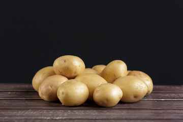 Fresh potatoes on the wood background