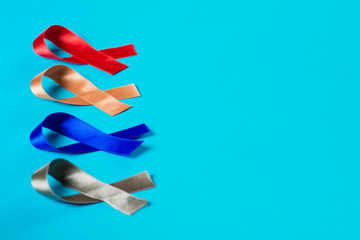 Different colored ribbons on blue background. Conceptual. Copy space.