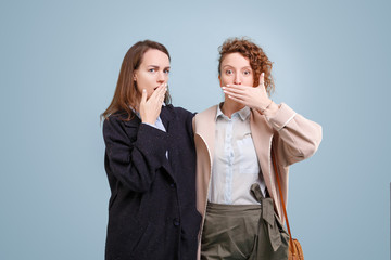 Embarrassed girls outrageously close their mouths