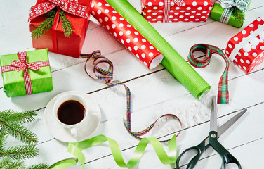 colorful papers for wrapping Christmas gifts and scissors on a white old wooden table