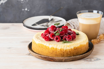 Vanilla New York cheesecake with raspberries and coffee with milk. Copy space.