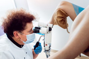 Gynecologist examining a patient with a microscope.