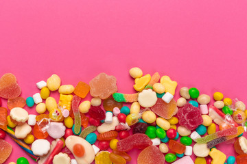 Fototapeta na wymiar Colorful lollipops on a pink background