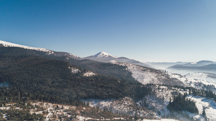 Aerial view of the mountains. Bukovel. Carpathians. Snow. Winter. Forest. Trees. Day.