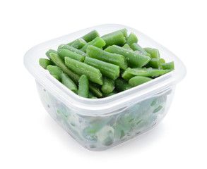 Plastic container with frozen green beans on white background