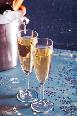 Champagne bottle in bucket with ice and glasses of champagne
