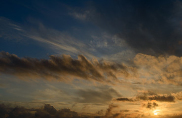 Dramatic sunset sky with dark clouds.