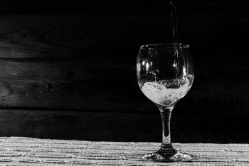 Champagne is poured into a glass, at the bottom of which is an olive