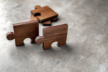 Fototapeta premium Pieces of wooden puzzle on grey textured background
