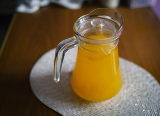 Glass carafe with compote from sea-buckthorn in the kitchen. Shallow depth of field.