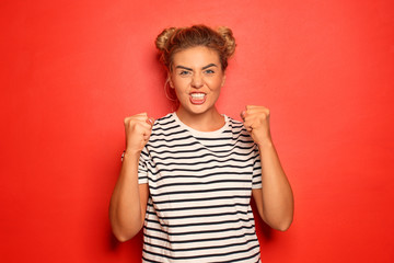 Portrait of angry young woman on color background