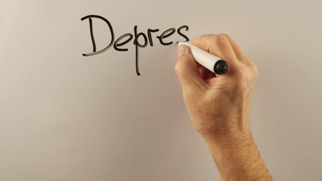 Man explains link between depression and manifestation of irritability on a whiteboard