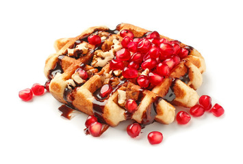 Tasty waffle with nuts, pomegranate seeds and chocolate topping on white background