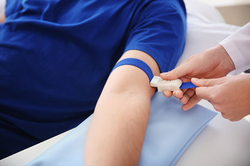 Female doctor preparing male donor for blood transfusion in hospital