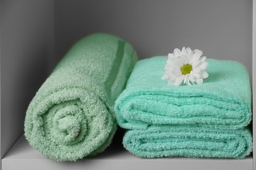 Clean soft towels on shelf, closeup