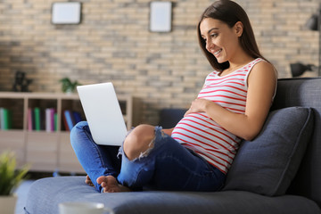 Young pregnant woman working at home