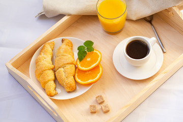 Breakfast in bed with coffee, croissants and juice