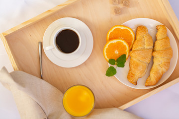 Breakfast in bed with coffee, croissants and juice