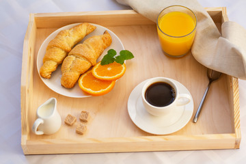 Breakfast in bed with coffee, croissants and juice