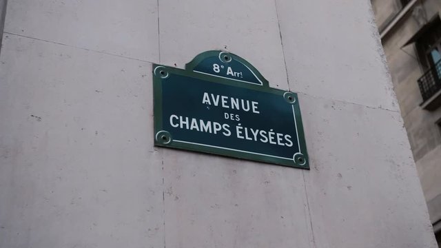 Classic street sign of Avenue Champs Elysees or Elysian Fields located on a house in Paris. France. Shot with parallax effect relative to houses in the background. Illustration of shopping and