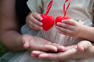 Red hearts in children's hands. The girl is holding red hearts. Concept family, happiness, love, valentine's day